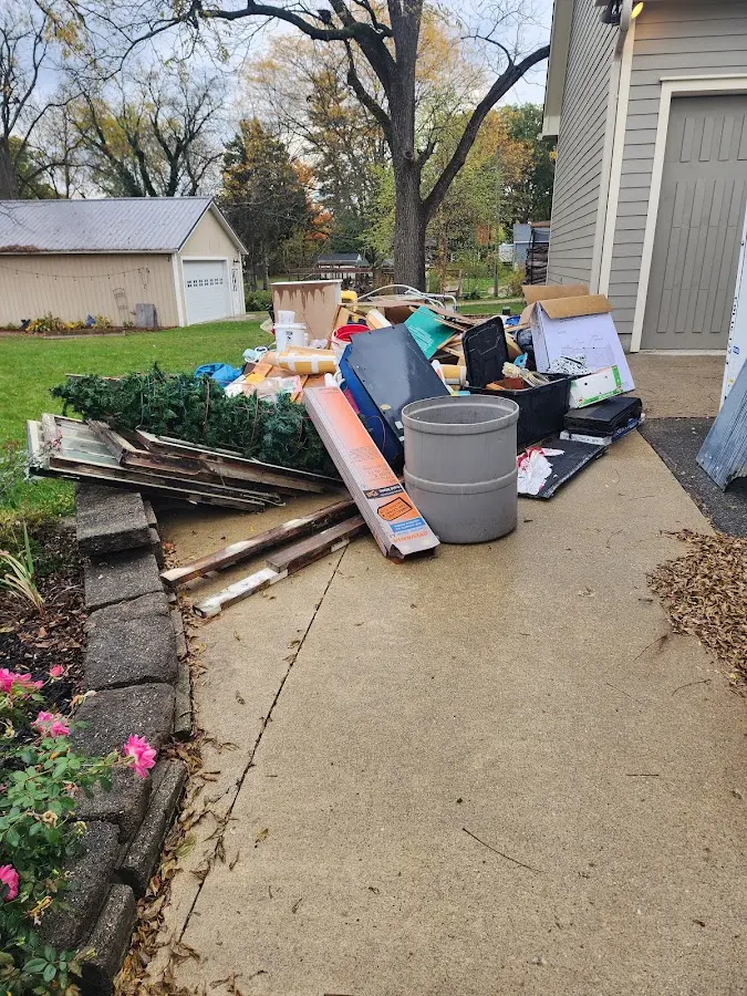 Dumpster being loaded with debris for 12 Yard Dumpster Rental in Myrtle Grove